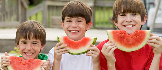 three boys holding watermelon slices